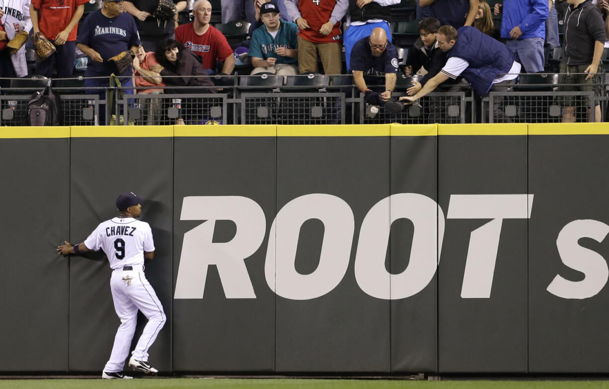 Seattle Mariners center fielder Endy Chavez watches as fans reach for the home run ball of Pittsburgh Pirates' Russell Martin in the second inning Tuesday.