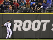 Seattle Mariners center fielder Endy Chavez watches as fans reach for the home run ball of Pittsburgh Pirates' Russell Martin in the second inning Tuesday.