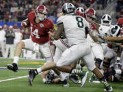 Alabama quarterback Jake Coker (14) tries to escape Michigan State defense during the second half of the Cotton Bowl NCAA college football semifinal playoff game, Thursday, Dec. 31, 2015, in Arlington, Texas.