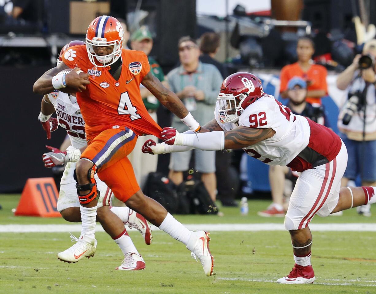 Clemson quarterback Deshaun Watson (4) runs with the ball as Oklahoma defensive tackle Matthew Romar (92) attempts to stop him, during the first half of the Orange Bowl NCAA college football semifinal playoff game, Thursday, Dec. 31, 2015, in Miami Gardens, Fla.