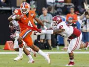 Clemson quarterback Deshaun Watson (4) runs with the ball as Oklahoma defensive tackle Matthew Romar (92) attempts to stop him, during the first half of the Orange Bowl NCAA college football semifinal playoff game, Thursday, Dec. 31, 2015, in Miami Gardens, Fla.