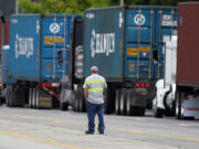 A driver looks on as container trucks line up along the highway at the Port of Portland near Terminal 6 on June 22.