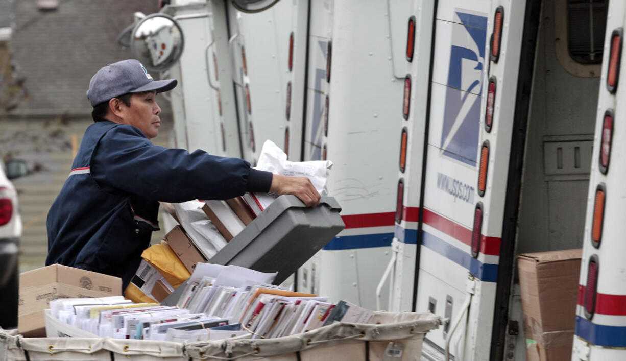 Letter carrier Diosdado Gabnat moves boxes of mail into his truck to begin delivery at a post office in Seattle.