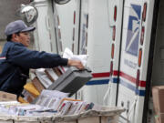 Letter carrier Diosdado Gabnat moves boxes of mail into his truck to begin delivery at a post office in Seattle.