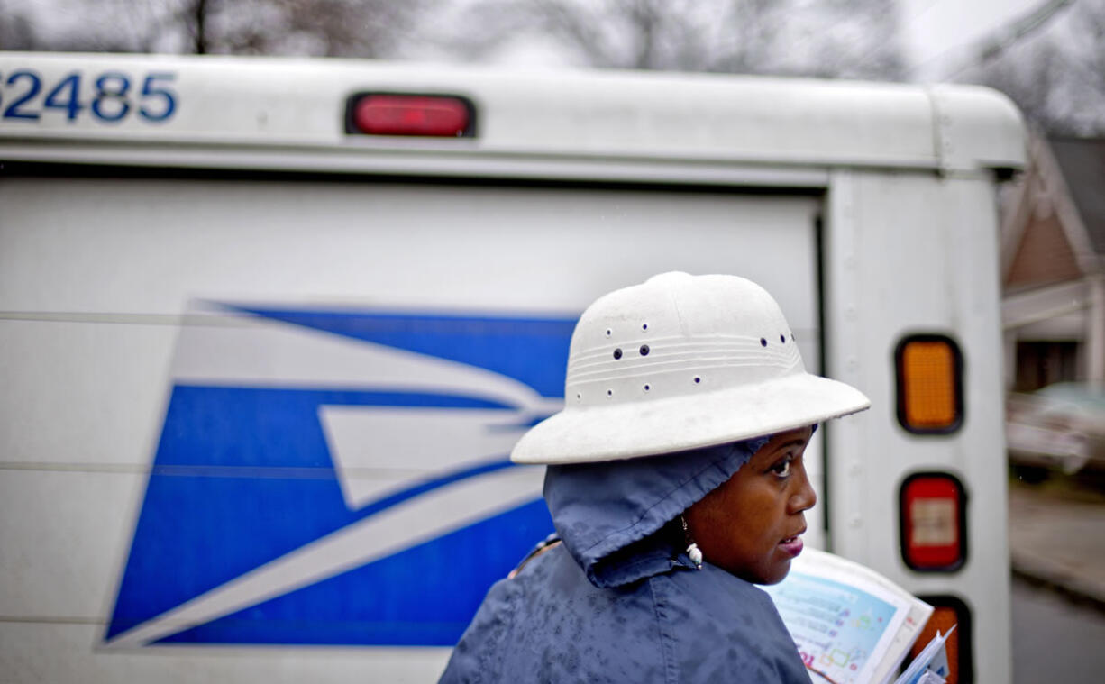 U.S. Postal Service letter carrier Jamesa Euler delivers mail in the rain in Atlanta. The U.S.