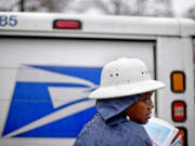 U.S. Postal Service letter carrier Jamesa Euler delivers mail in the rain in Atlanta. The U.S.