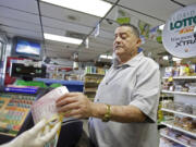 Remberto Gonzalez purchases Powerball lottery tickets at a local store in Hialeah, Fla., on Tuesday.