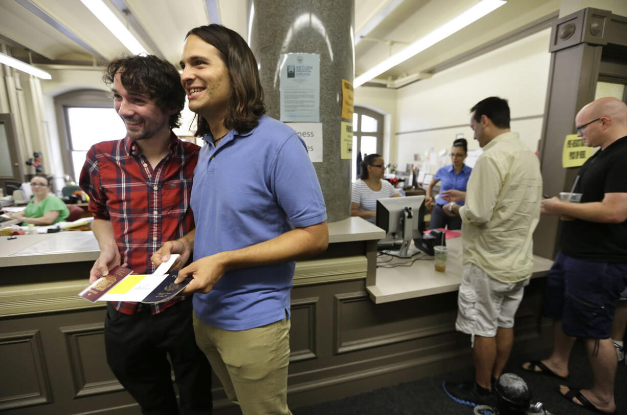 Gary McDowell, left, and Zachary Marcus, both of Providence, R.I., display their newly obtained marriage certificate at City Hall in Providence on Thursday.