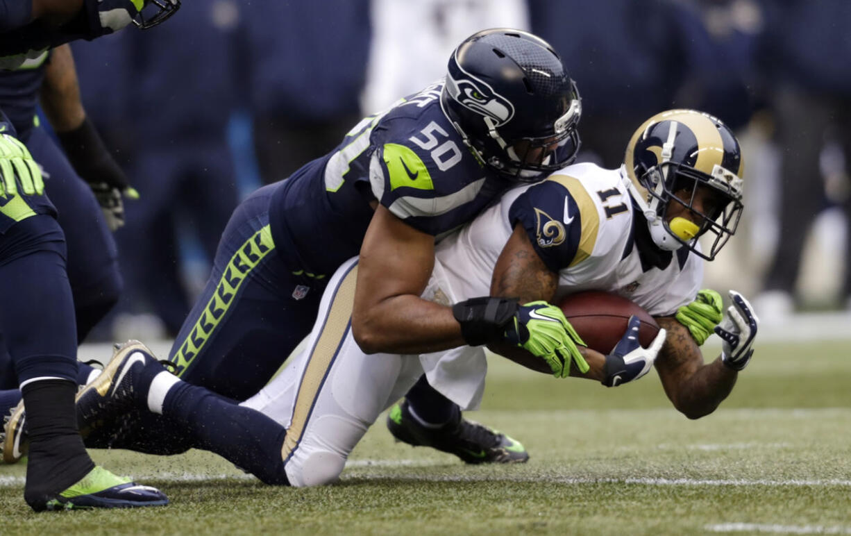 Seattle Seahawks' K.J. Wright (50) brings down St. Louis Rams' Tavon Austin on a carry in the first half of an NFL football game, Sunday, Dec. 27, 2015, in Seattle.