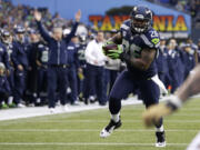 Seattle Seahawks' Michael Robinson heads for the end zone as Seahawks head coach Pete Carroll signals the touchdown in the background during the third quarter Sunday.