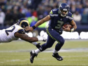 Seattle Seahawks quarterback Russell Wilson (3) pushes past St. Louis Rams' Eugene Sims for a 15-yard run in the second half of an NFL football game, Sunday, Dec. 30, 2012, in Seattle. The Seahawks won 20-13.