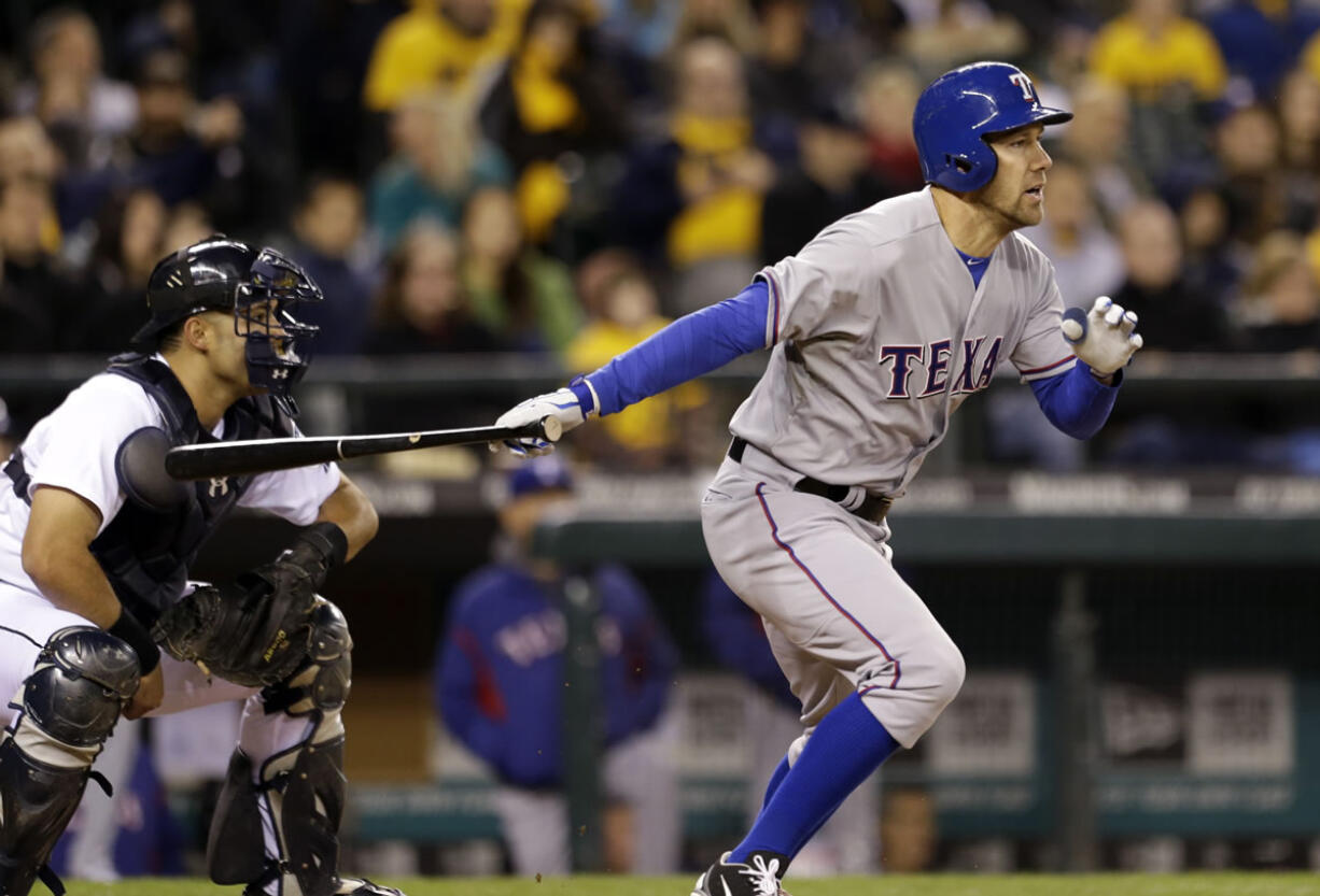 Texas Rangers' David Murphy singles in the go-ahead run as Seattle Mariners catcher Jesus Montero looks on in the fifth inning Thursday.