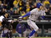 Texas Rangers' David Murphy singles in the go-ahead run as Seattle Mariners catcher Jesus Montero looks on in the fifth inning Thursday.