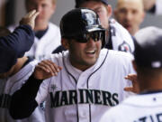 Seattle Mariners' Jesus Montero is congratulated after scoring the tie-breaking run against the Texas Rangers in the sixth inning Sunday.