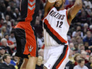 Portland's LaMarcus Aldridge (12) goes to the basket around the defense of Toronto's Jose Calderon during the second half Monday.