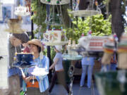 Mikiko Flynn and her husband, Tom, look at recycled bird feeders at last year's Recycled Arts Festival, a celebration of art created from recycled materials.