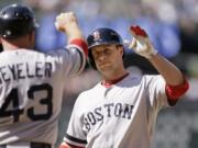 Boston Red Sox's Daniel Nava, right, is congratulated by first base coach Arnie Beyeler after hitting an RBI-single against the Seattle Mariners in the 10th inning Thursday.