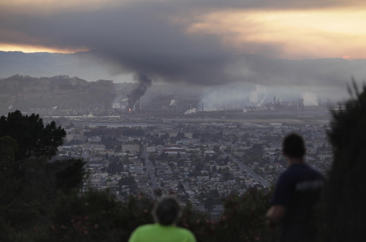 People watch smoke rise from the Chevron refinery in Richmond, Calif., from a vantage point in the El Cerrito, Calif., hills Monday, Aug. 6, 2012.