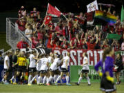 Fans celebrate with the Portland Thorns after Christine Sinclair  shot the winning goal to give the Thorns a 2-1 win over the Seattle Reign during the Thorns' final match of the regular season Saturday  in Tukwila.