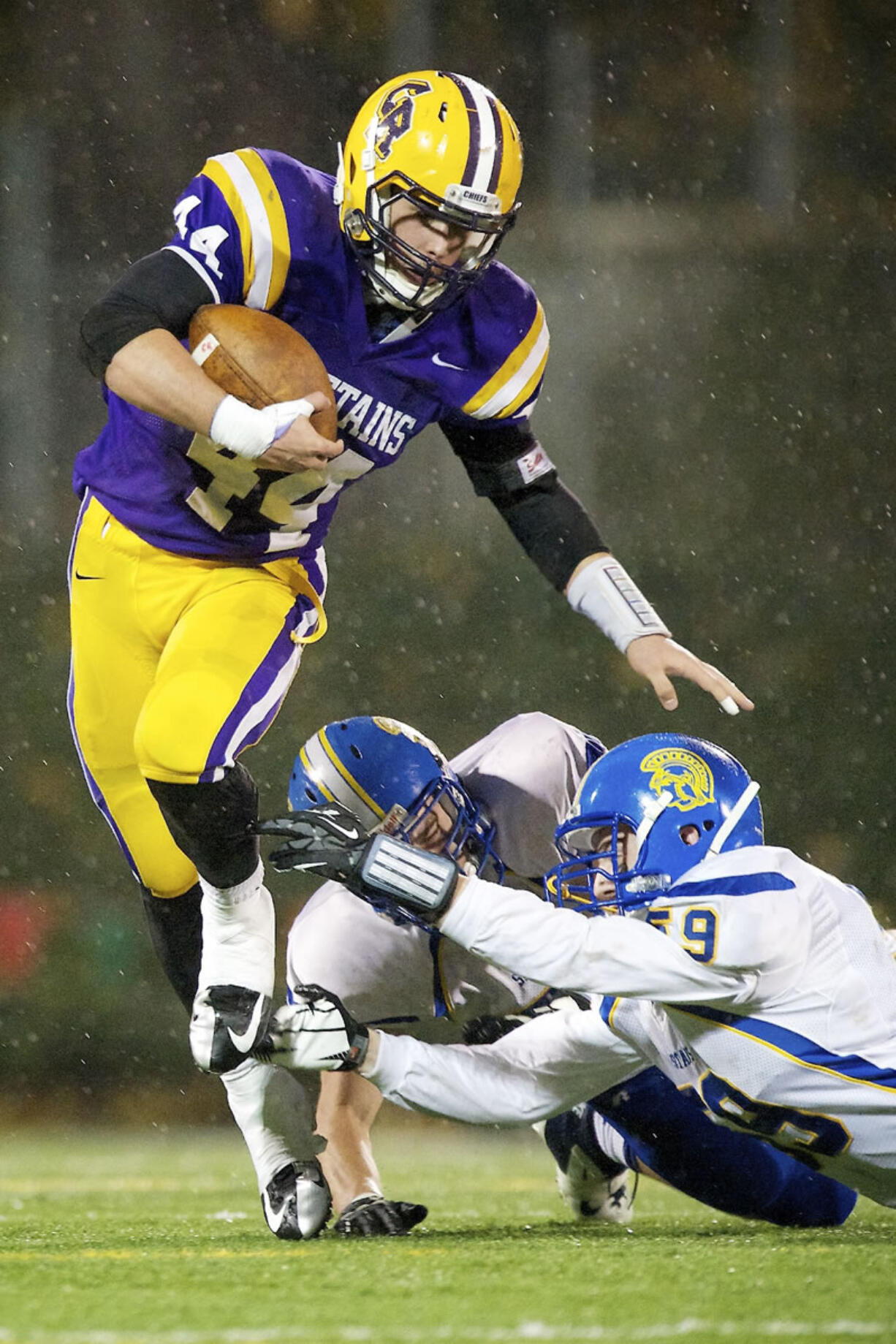 Columbia River's Remick Kawawaki (44), playing here against Bainbridge in a Class 3A playoff game, will be dodging tackles -- or making them -- in the Ivy League next fall for the Yale Bulldogs.