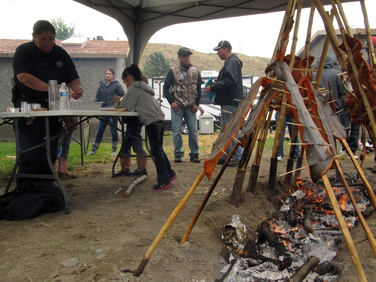 Members of the Confederated Colville Tribes prepare a salmon feast Thursday to dedicate a new fish hatchery in Bridgeport. The hatchery will release nearly 3 million salmon to the wild each year.