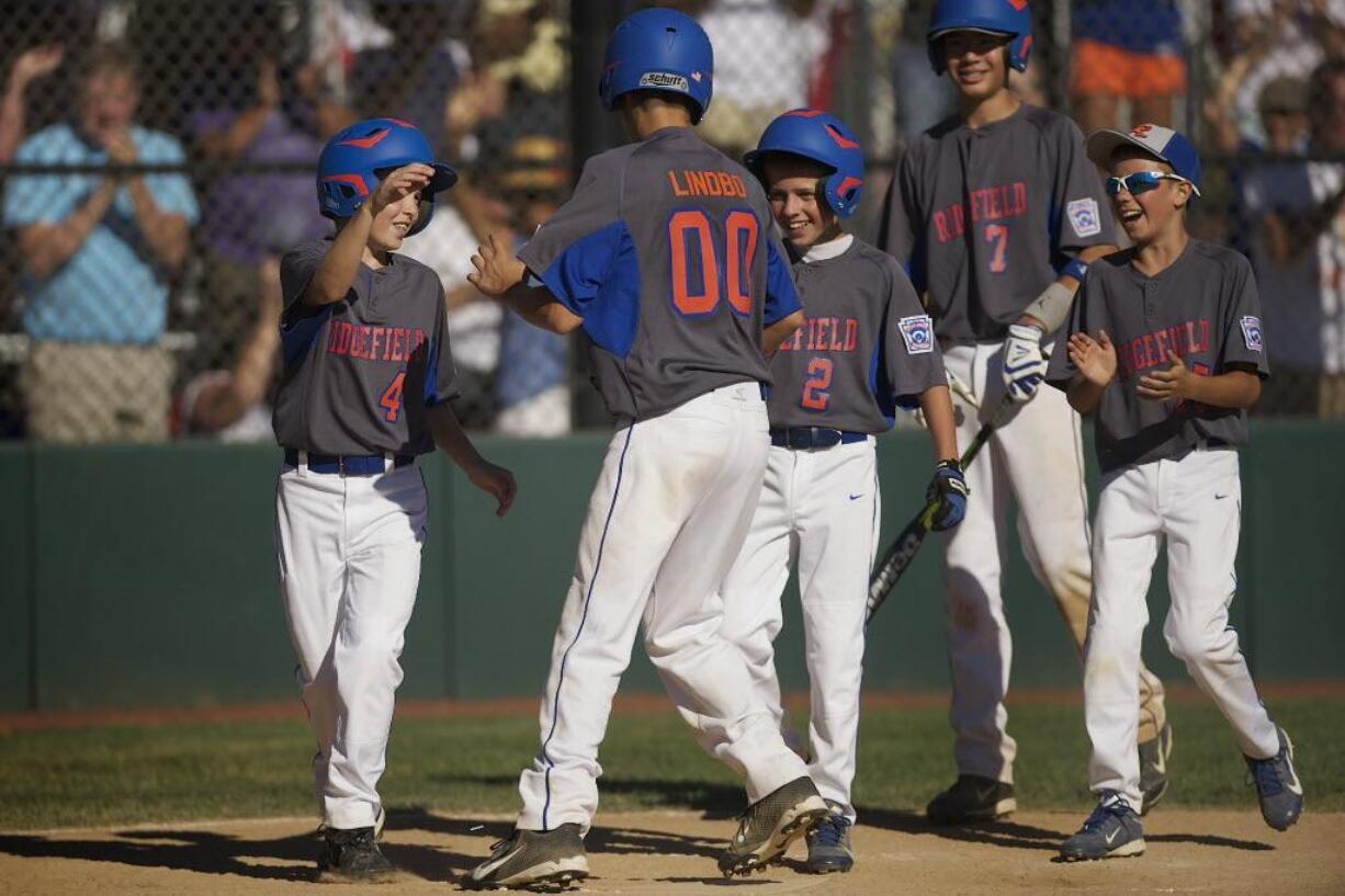 Ridgefield's Joe David Lindbo (00) celebrates with teammates after hitting a home run in Monday's game at the Washington State Little League tournament at Luke Jensen Sports Park in Vancouver.