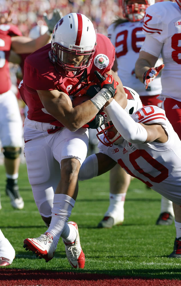 Stanford running back Kelsey Young rushes through the would-be tackle of Wisconsin's Devin Smith for a touchdown to cap the opening drive.