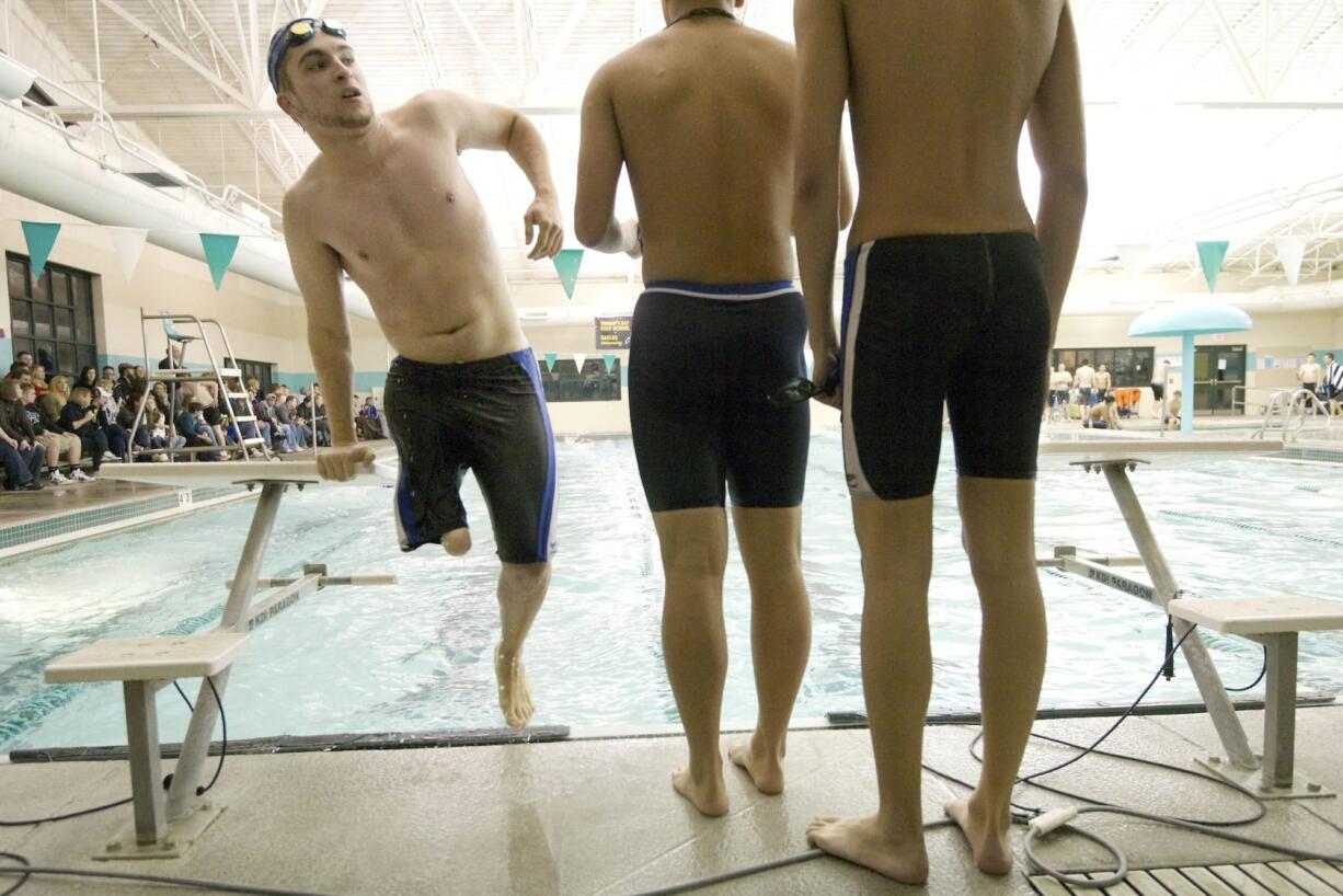 Ryker Phillips, 17, left, a senior on the Mountain View High School swim team exits the pool after competing in the 400 yard freestyle relay Jan.