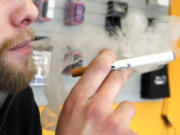 A sales associate demonstrates the use of a electronic cigarette and the smoke like vapor that comes from it in Aurora, Colo., in 2011.