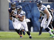 Seattle Seahawks quarterback Russell Wilson (3) rushes past Chicago Bears defensive end Corey Wootton (98) during the second half Sunday.