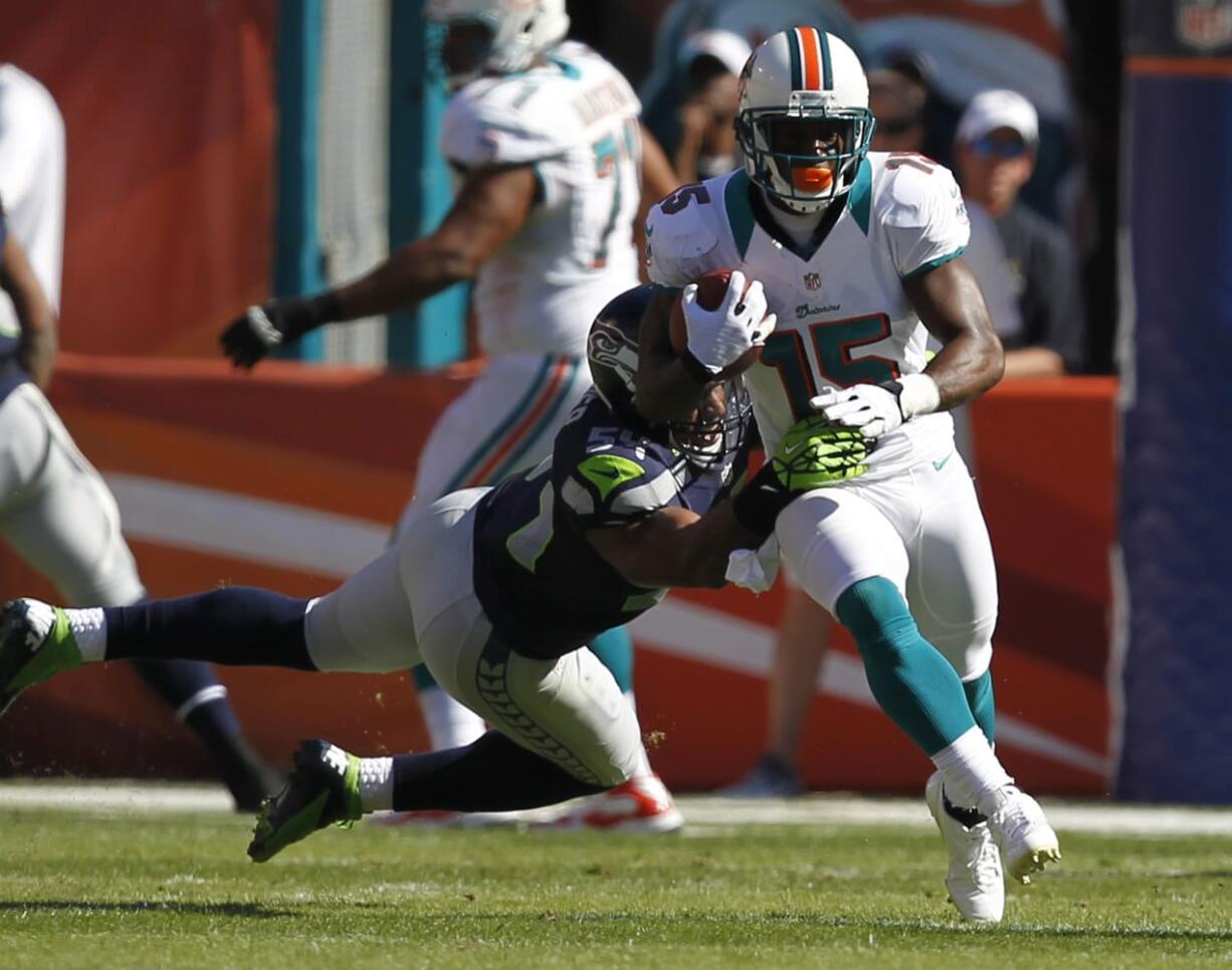 Seattle Seahawks middle linebacker Bobby Wagner (54) tackles Miami Dolphins wide receiver Davone Bess (15), during the first half Sunday.