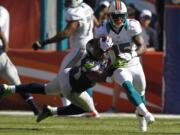 Seattle Seahawks middle linebacker Bobby Wagner (54) tackles Miami Dolphins wide receiver Davone Bess (15), during the first half Sunday.