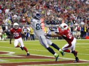 Seattle Seahawks tight end Zach Miller (86) pulls in a touchdown pass as Arizona Cardinals strong safety Yeremiah Bell (37) and Rashad Johnson (26) defend during the first half on Thursday, Oct. 17, 2013, in Glendale, Ariz.