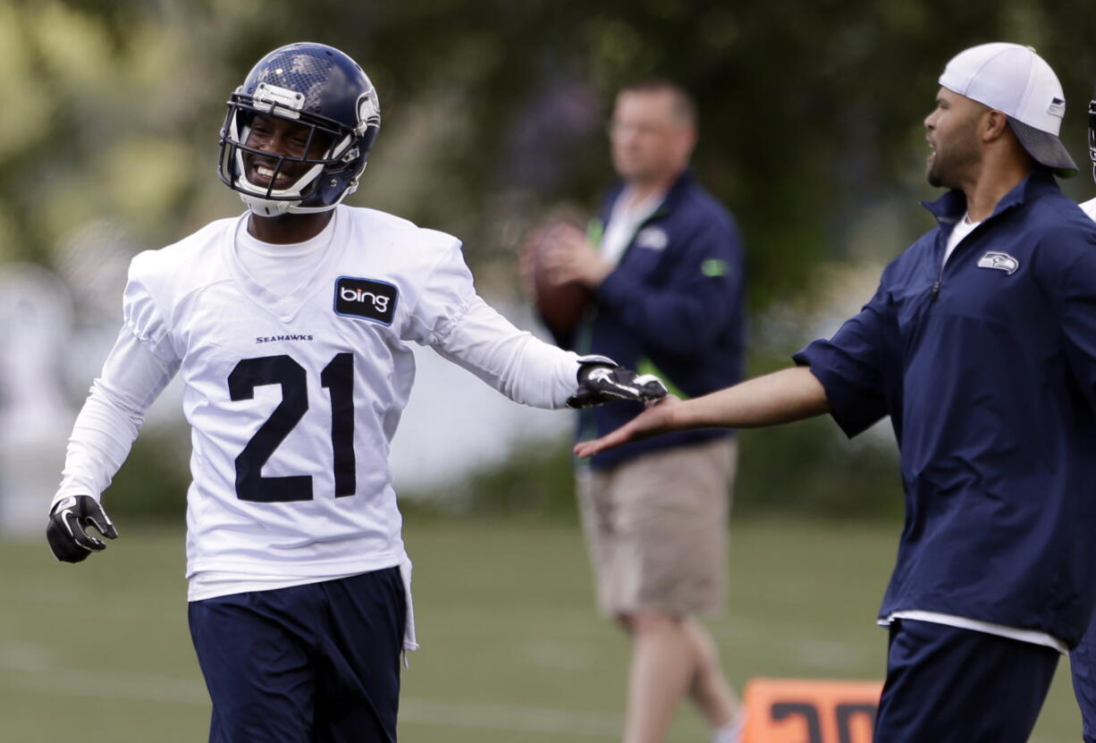 Seattle Seahawks' Antoine Winfield (21) is congratulated by secondary coach Kris Richard after a turn at scrimmage during an NFL football minicamp on Wednesday, June 12, 2013, in Renton, Wash (AP Photo/Elaine Thompson)