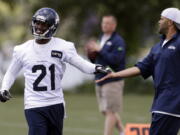 Seattle Seahawks' Antoine Winfield (21) is congratulated by secondary coach Kris Richard after a turn at scrimmage during an NFL football minicamp on Wednesday, June 12, 2013, in Renton, Wash (AP Photo/Elaine Thompson)