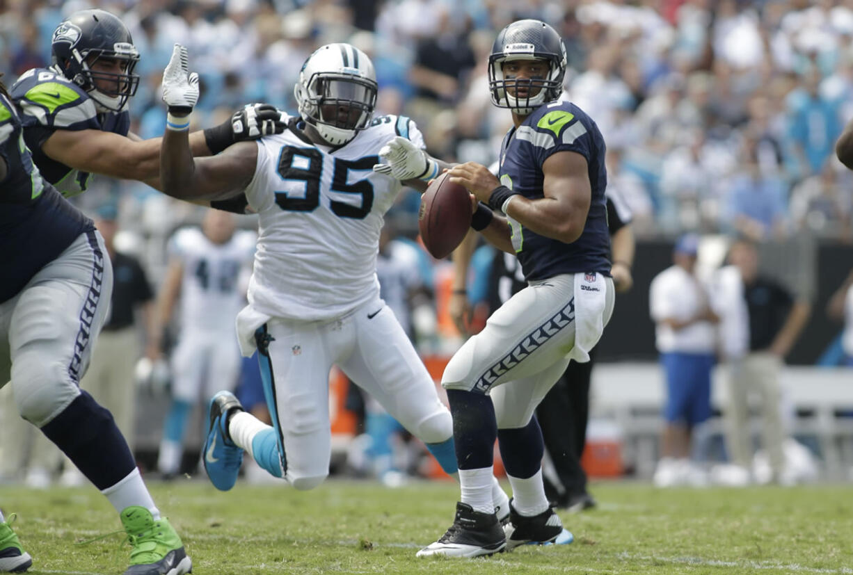 Seattle Seahawks quarterback Russell Wilson (3) looks to pass under pressure from Carolina Panthers' Charles Johnson (95) Sunday in Charlotte, N.C. Wilson threw for 320 yards and a touchdown in the Seahawks' 12-7 win.