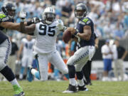 Seattle Seahawks quarterback Russell Wilson (3) looks to pass under pressure from Carolina Panthers' Charles Johnson (95) Sunday in Charlotte, N.C. Wilson threw for 320 yards and a touchdown in the Seahawks' 12-7 win.