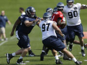 Seattle Seahawks defensive tackle Jordan Hill (97) is blocked by Seahawks' Jared Smith, left, as Hill and defensive tackle Jesse Williams (90) try to get to quarterback Jerrod Johnson, second from right, during practice drills at  rookie minicamp on Friday.