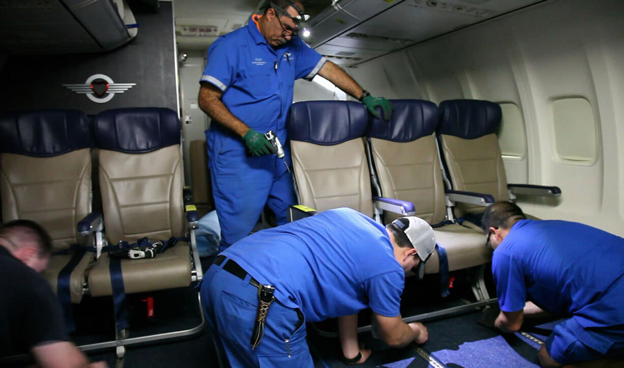 Southwest Airlines aircraft technicians install newer, skinnier seats on a 737 at the carrier's headquarters in Dallas.