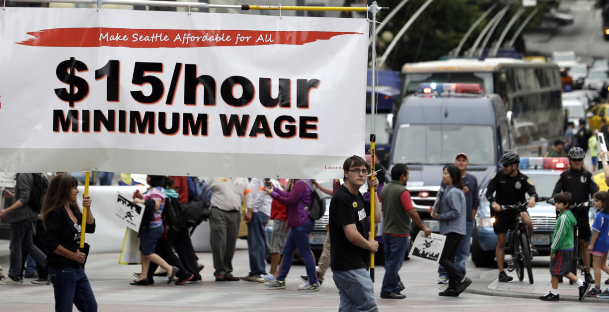 Demonstrators protesting what they say are low wages and improper treatment for fast-food workers march in downtown Seattle on Aug. 1. Seattle Mayor Mike McGinn said Wednesday he thought $15 was a &quot;fair starting point&quot; for the minimum wage discussion. McGinn challenger Ed Murray recently announced that he would push for a $15 minimum wage but planned to proceed with a phased-in approach.