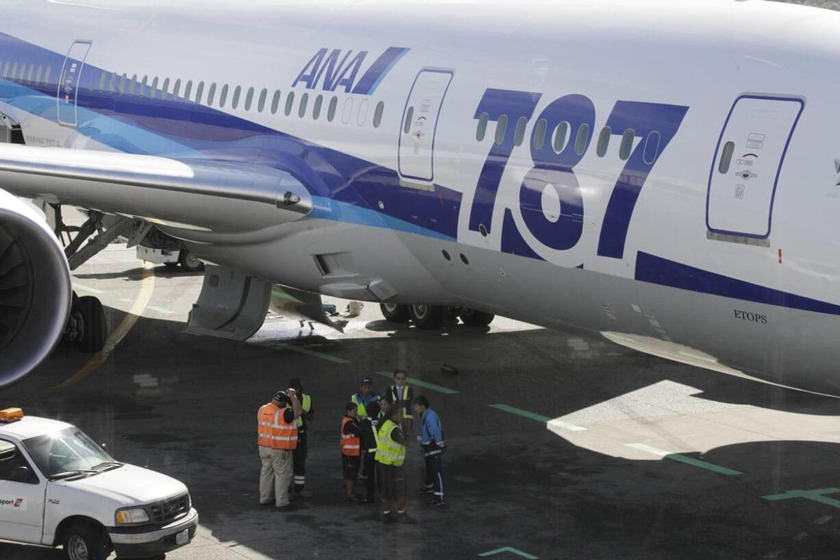 Ramp workers stand near a Boeing 787 operated by All Nippon Airways during a maintenance delay at Seattle-Tacoma International Airport on Monday.