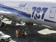 Ramp workers stand near a Boeing 787 operated by All Nippon Airways during a maintenance delay at Seattle-Tacoma International Airport on Monday.