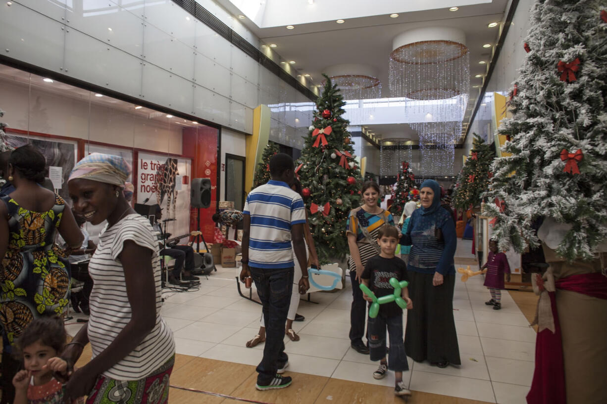 People walk past Christmas trees at a shopping mall in  Darkar, Senegal.