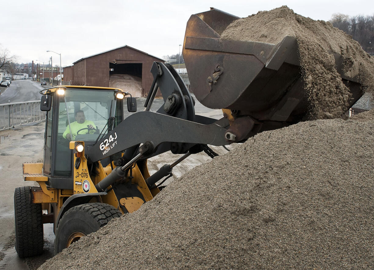 Joseph Lebeau mixes road sand and salt at the Department of Public Works facility in Worcester, Mass., as the Worcester DPW prepares for winter weather Sunday.