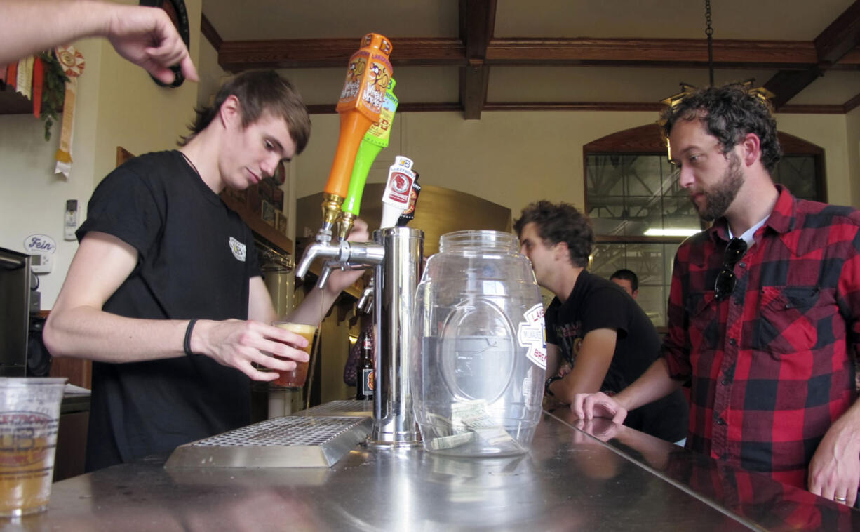 In this Oct. 3, 2013 photo, Dylan Maz pours beer during a tour  at Lakefront Brewery in Milwaukee.