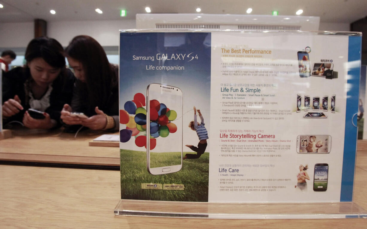 Visitors operate Samsung Electronics' Galaxy S4 smartphones Friday at a showroom in its headquarters in Seoul, South Korea. Samsung Electronics Co.