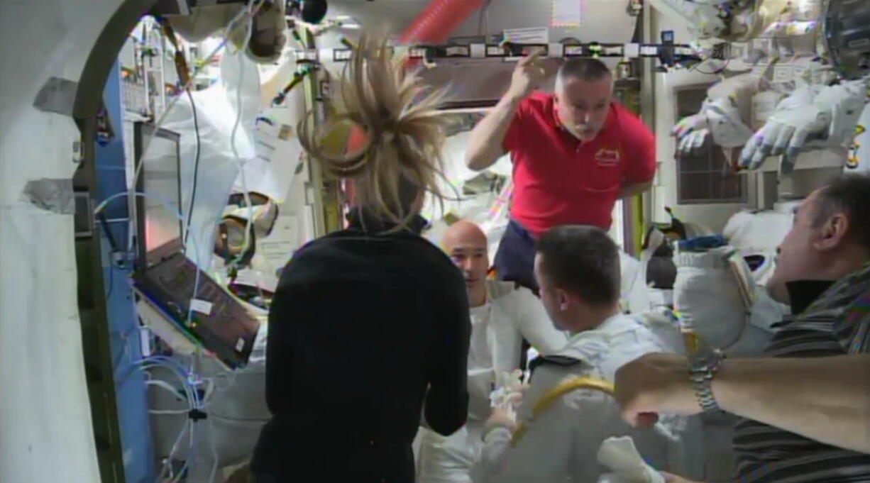 NASA
Astronauts discuss the aborted spacewalk aboard the International Space Station on Tuesday. A water leak in the helmet of Luca Parmitano, at center facing camera in white suit, caused what should have been a routine spacewalk to come to an abrupt end.