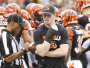 Cincinnati Bengals quarterback Andy Dalton walks the sidelines in a cast on his throwing hand after being taken out of the game with an injury in the first half of an NFL football game against the Pittsburgh Steelers, Sunday, Dec. 13, 2015, in Cincinnati.