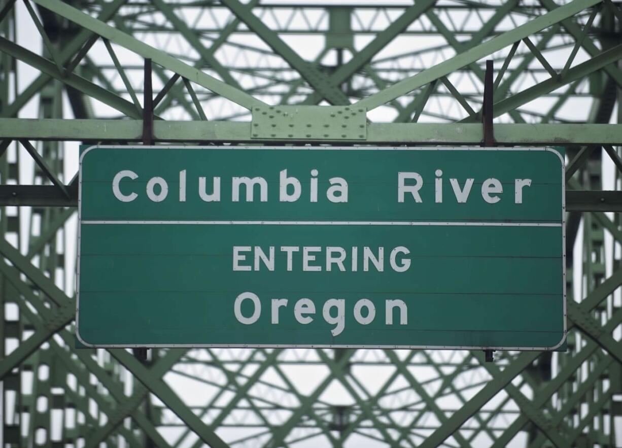 A road sign on the Interstate 5 Bridge heading southbound welcomes drivers to Oregon.