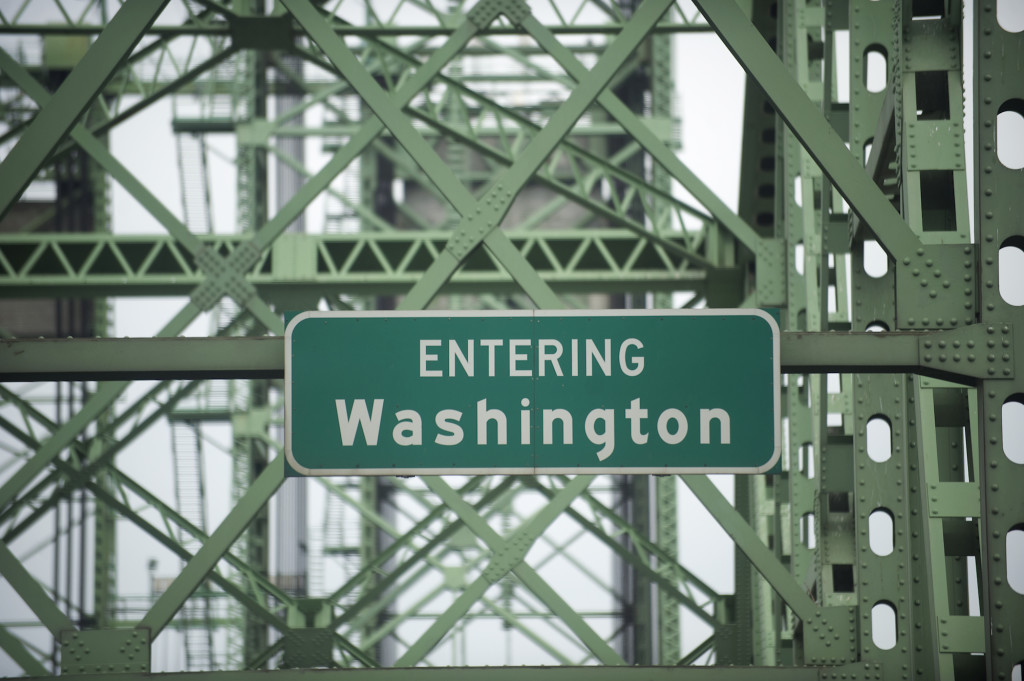 Road signs on the Interstate 5 bridge welcomes drivers to Washington.